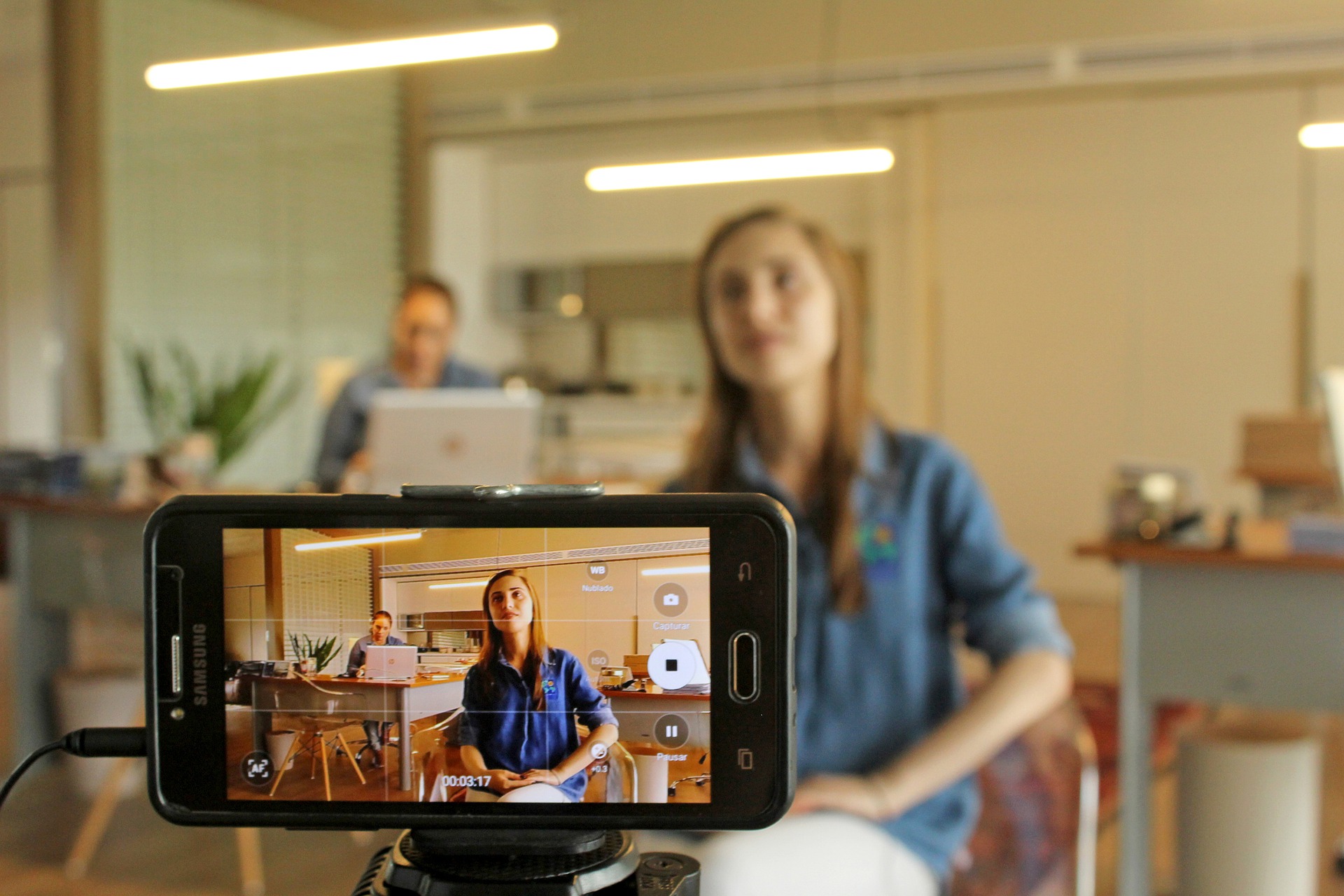 Woman posing in front of a cell phone camera